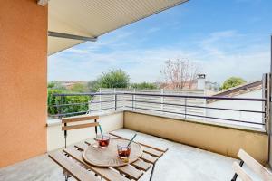 eine Terrasse mit Tisch und Stühlen auf einem Balkon in der Unterkunft Charming T2 in Frouzins in Frouzins