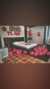 Zimmer mit einem Bett und roten Ballons auf dem Boden in der Unterkunft La Cabañita in Mocoa