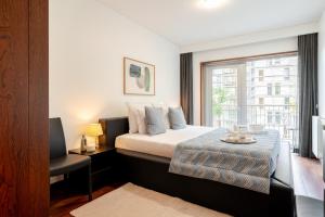 MassarelosにあるPremium Flat w/ Pool, Gym & Garage by HostWiseのベッドと窓のある寝室