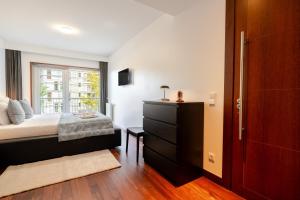 MassarelosにあるPremium Flat w/ Pool, Gym & Garage by HostWiseのベッドルーム1室(ベッド1台、窓、ドレッサー付) +44枚の写真