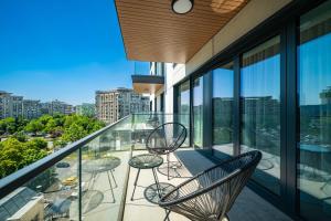 un balcon avec des chaises et des tables sur un immeuble dans l'établissement Spacious 2BR Apartment - with Balcony and View, à Vatra Mînăstirii Cotroceni