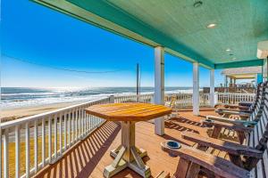 a porch with a table and benches on the beach at Stunning Beachfront Dog Friendly Sleeps 8 in Caplen