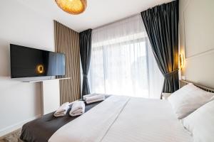 une chambre avec un grand lit avec une télévision au mur dans l'établissement Spacious 2BR Apartment - with Balcony and View, à Vatra Mînăstirii Cotroceni