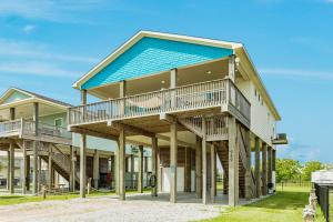 a large house with a blue roof at Prime Steps to Beach Large Deck Pet Friendly in Stingaree