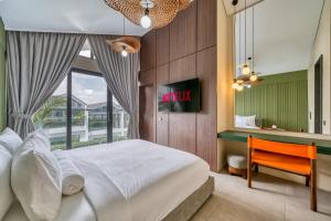 een slaapkamer met een bed, een bureau en een raam bij Melasti Dream Residence in Uluwatu +47 foto's