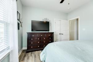 a bedroom with a bed and a television on a dresser at Prime Steps to Beach Large Deck Pet Friendly in Stingaree