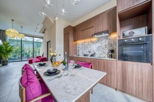 een keuken met een tafel en roze stoelen in een kamer bij Melasti Dream Residence in Uluwatu