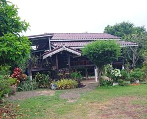 a house with a garden in front of it at Bo Cabin in Garden โบคาบิน อิน การ์เดน in Ban Nong Ki