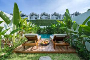 twee stoelen en een fruitschaal op een houten terras bij Melasti Dream Residence in Uluwatu