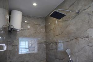 um banheiro com chuveiro e parede de pedra em AK Residency em Yercaud mais 17 fotografias