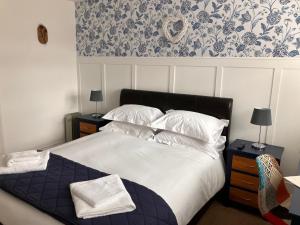 a bedroom with a bed with white sheets and pillows at White hart public house in Ashill