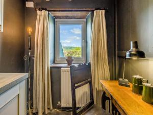 une cuisine avec une fenêtre avec un radiateur et une table dans l'établissement 3 Legged Duck Cottage, à Yspytty-Ystwyth