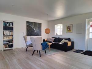 a living room with a couch and a table and chairs at GIMLEretreat in Marielyst