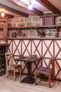a table and chairs in a room with a stone wall at Perla De Mar Hotel & Restaurant in Baku