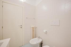 a white bathroom with a toilet and a sink at Cervino's Home - 20 min from Venice & Parking in Venice