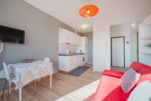 a living room with a table and a red couch at Cervino's Home - 20 min from Venice & Parking in Venice +12 photos