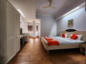 a bedroom with a large bed with red pillows at Park Palace Hotel in Kolkata +87 photos