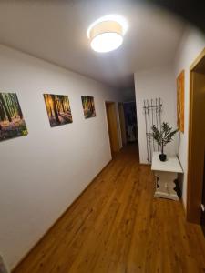 a room with three paintings on the wall and a table at Ferienwohnung Oskar in Gschwend
