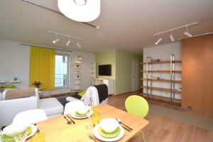 sala de estar con mesa de madera y sillas en Bright Home en Tallin