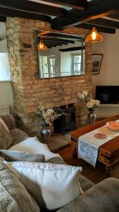a living room with a stone fireplace and a mirror at 8 Pudding Bag Lane in Exton