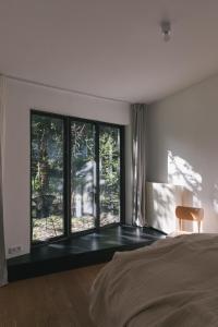a bedroom with a bed and a large window at Im Scheunhornweg in Werder