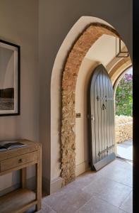 an archway leading to a door in a room at Luxury Cotswolds Retreat nr Estelle Manor 