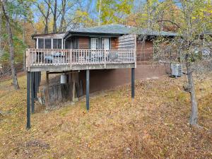 une maison avec une terrasse au milieu d'une cour dans l'établissement Resort Amenities Fire Pit Deck Grill & More, à Baxter