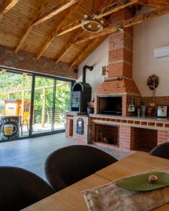 a living room with a brick fireplace and a table at Pensiunea Plaiul Domnesc Runcu in Runcu +66 photos