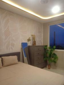 a bedroom with a bed and a window and a dresser at 49homestay in Ấp Khánh Phước (1)