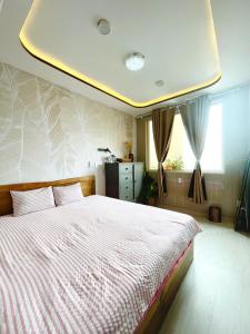 a bedroom with a large bed with a ceiling at 49homestay in Ấp Khánh Phước (1)
