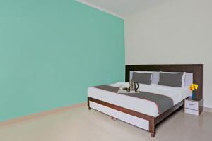 a bedroom with a large bed with a blue background at Hotel O B.S Residency in Gurgaon +20 photos