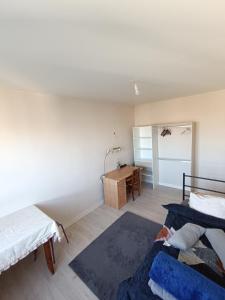 a bedroom with two beds and a desk in it at Beautiful private room in apartment in Saint-Pierre-des-Corps