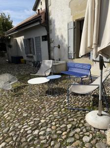 a group of chairs and tables and an umbrella at Domaine à la Loëx in Geneva +13 photos