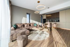 un salon avec un canapé et une table dans l'établissement Metropolitan Spacious Retreat - Balcony and View, à Vatra Mînăstirii Cotroceni