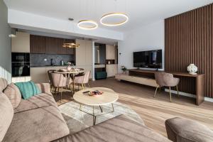 un salon avec un canapé et une table dans l'établissement Metropolitan Spacious Retreat - Balcony and View, à Vatra Mînăstirii Cotroceni