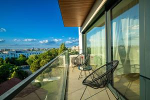 d'un balcon avec deux chaises et une vue sur la ville. dans l'établissement Metropolitan Spacious Retreat - Balcony and View, à Vatra Mînăstirii Cotroceni