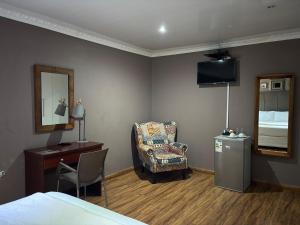 a bedroom with a bed and a chair and a desk at 23 on Camden Road Guesthouse in East London