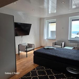 a bedroom with a bed and two chairs and a flat screen tv at Ferienwohnung in Bexbach