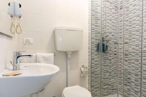 a bathroom with a toilet and a sink and a shower at The Sea Hotel in Rimini +34 photos