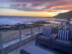 een balkon met een stoel en uitzicht op de oceaan bij Woelwaters Beach Villa in Herolds Bay