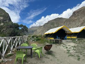 a group of chairs and tables in front of a tent at River Rock Camps in Jispa