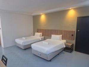 een hotelkamer met twee bedden en een tv bij USAS Resort, Kuala Kangsar in Kuala Kangsar