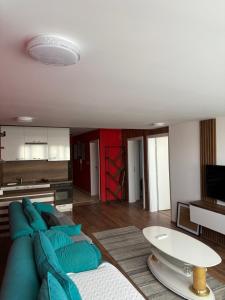 a living room with a blue couch and a kitchen at Heart of prishtina apartaments 5 in Pristina