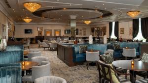 un restaurant avec des tables et des chaises et un bar dans l'établissement Mount Wolseley Hotel Spa & Golf Resort, à Tullow