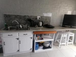 a kitchen with a sink and a counter top at Petite Selfcatering Accommodation Struisbaai SA in Struisbaai