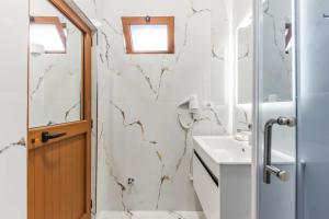 ein Badezimmer mit Dusche und Waschbecken in der Unterkunft Hotel Riti in Shirokë