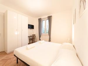 a white bedroom with a bed and a chair at RRRapido Sant' Ambrogio Suites and Rooms - Via Olona in Milan +37 photos