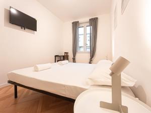 a bedroom with a bed with a tv on the wall at RRRapido Sant' Ambrogio Suites and Rooms - Via Olona in Milan