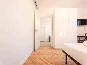 a bedroom with a bed and a wooden floor at RRRapido Sant' Ambrogio Suites and Rooms - Via Olona in Milan