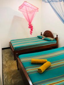 two twin beds in a room with a kite above them at Ancient Tree in Mirissa